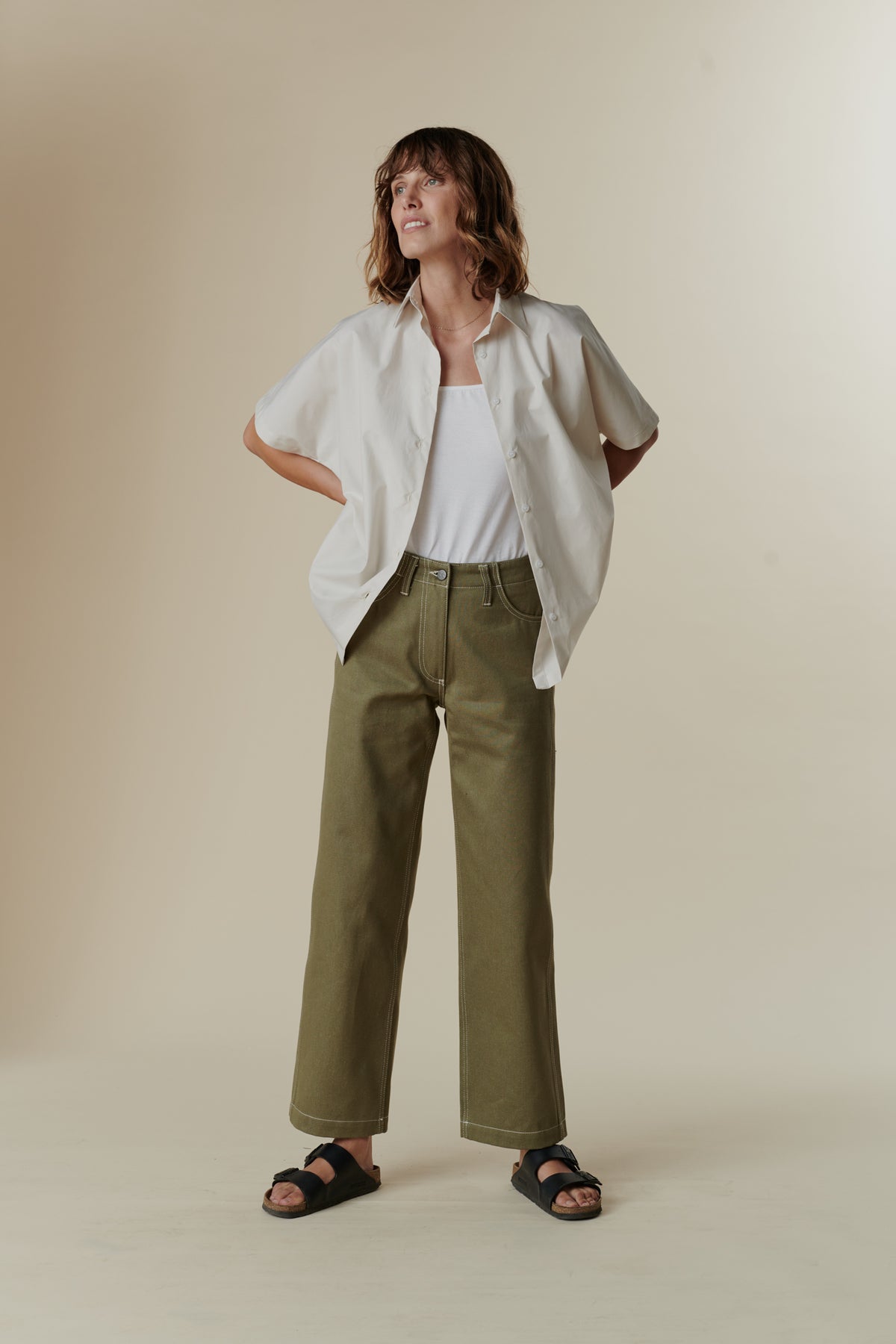 
            female wearing olive work jean and white unbuttoned ava shirt