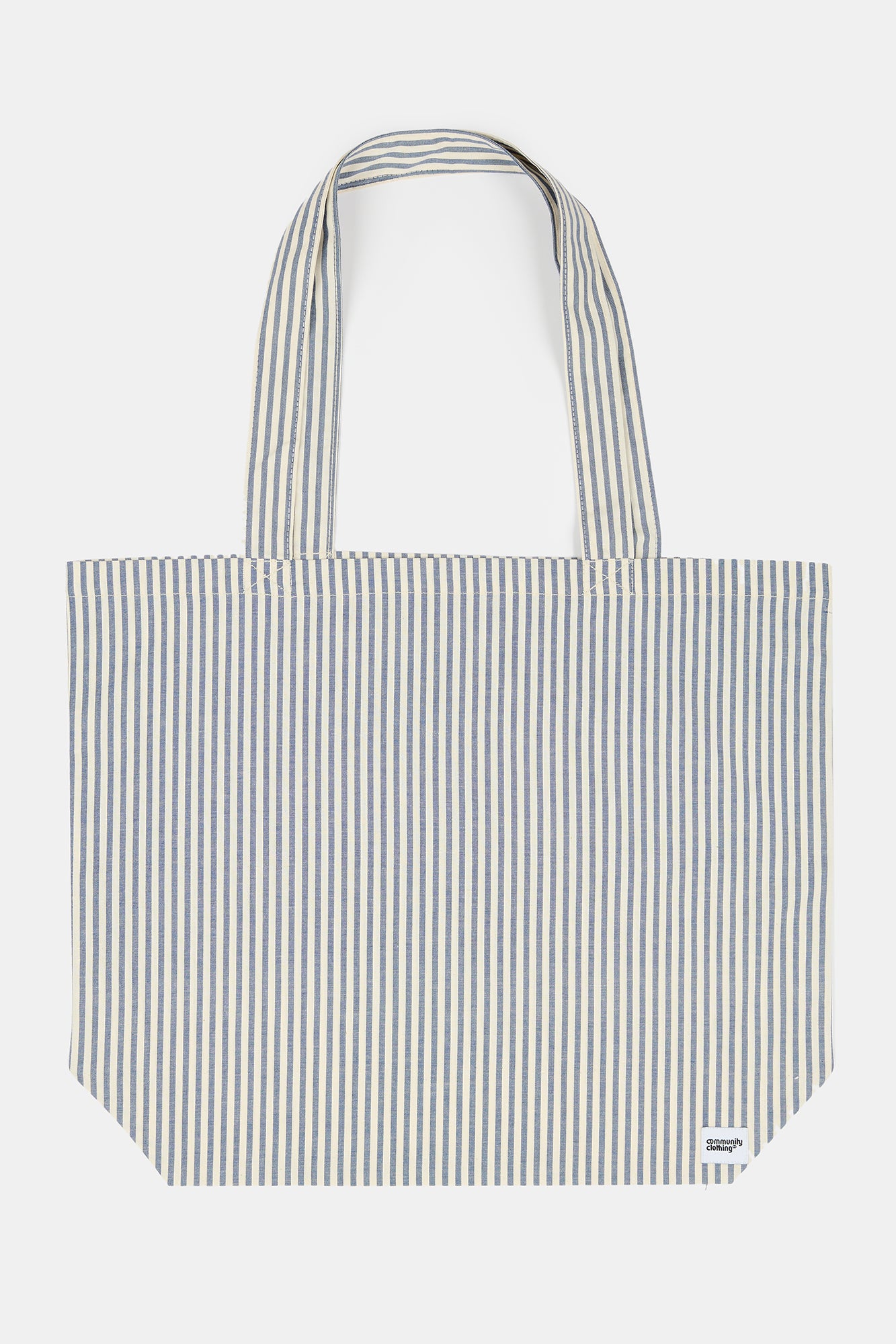 close up of the blue and white stripe tote bag over a ladies arm wearing short sleeve t shirt in stone and indigo jeans